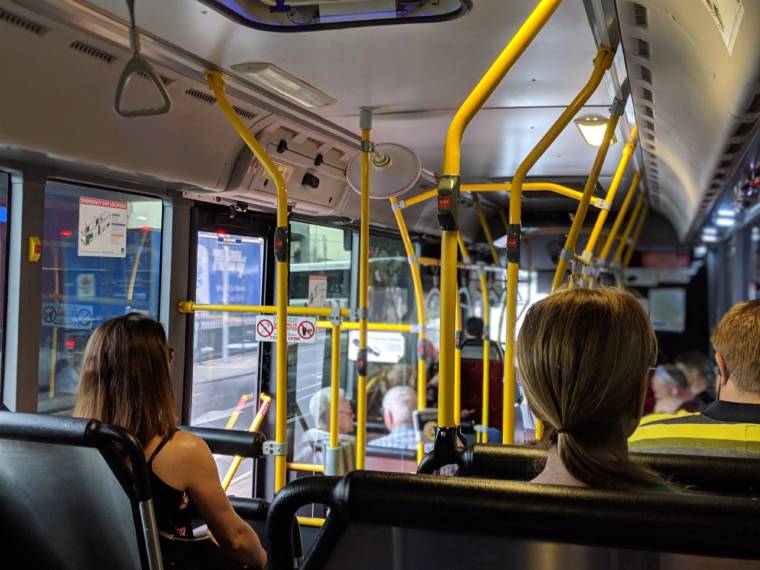 Ihmisiä istumassa kaupunkiliikenteen bussissa
